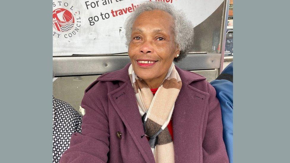 Joyce Morris-Wisdom sitting at a bus stop