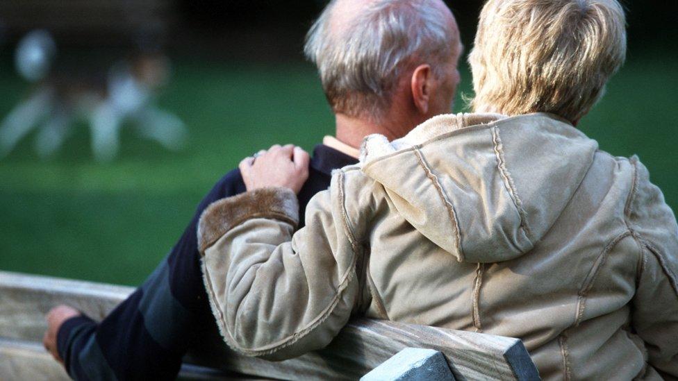 Older couple on a park bench - posed by models