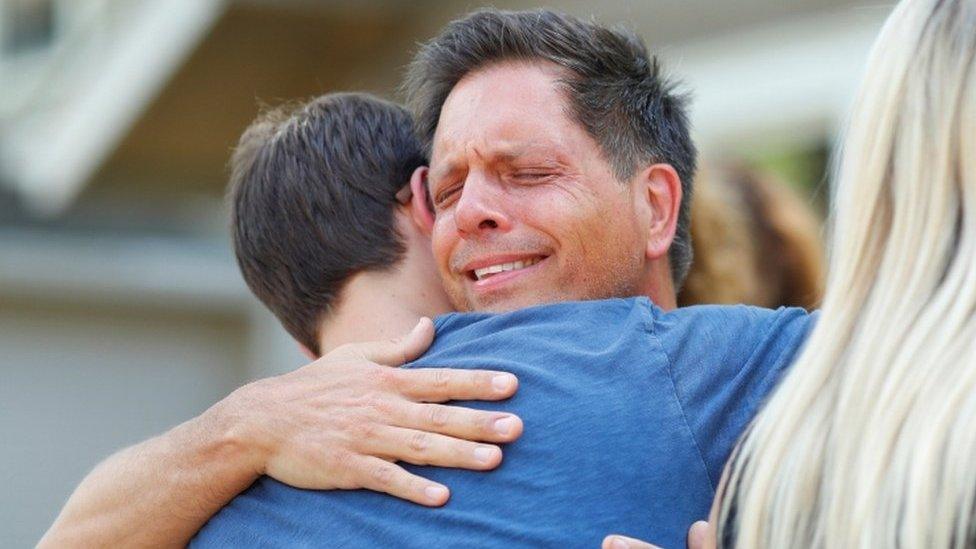 Don Damond hugs a neighbour after reading a statement about his fiancé