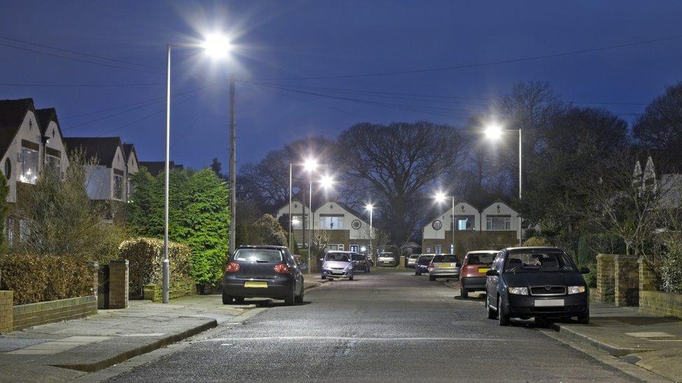 Parked cars on a lit residential street