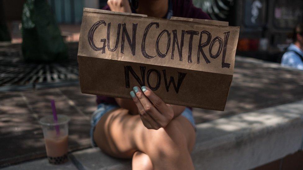 A woman holds a placard that say gun control now during a gun reform rally that was held in Dayton, Ohio in the wake of a mass shooting at the area earlier this month that left 9 dead and 27 wounded.