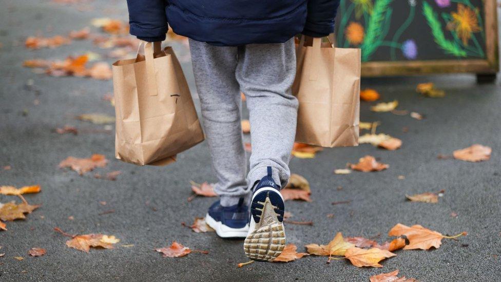 Boy carrying food bags