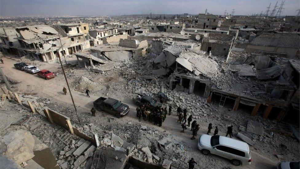 Syrian pro-government forces patrol Aleppo's Sheikh Saeed district on 12 December 2016, after retaking the area from rebel fighters