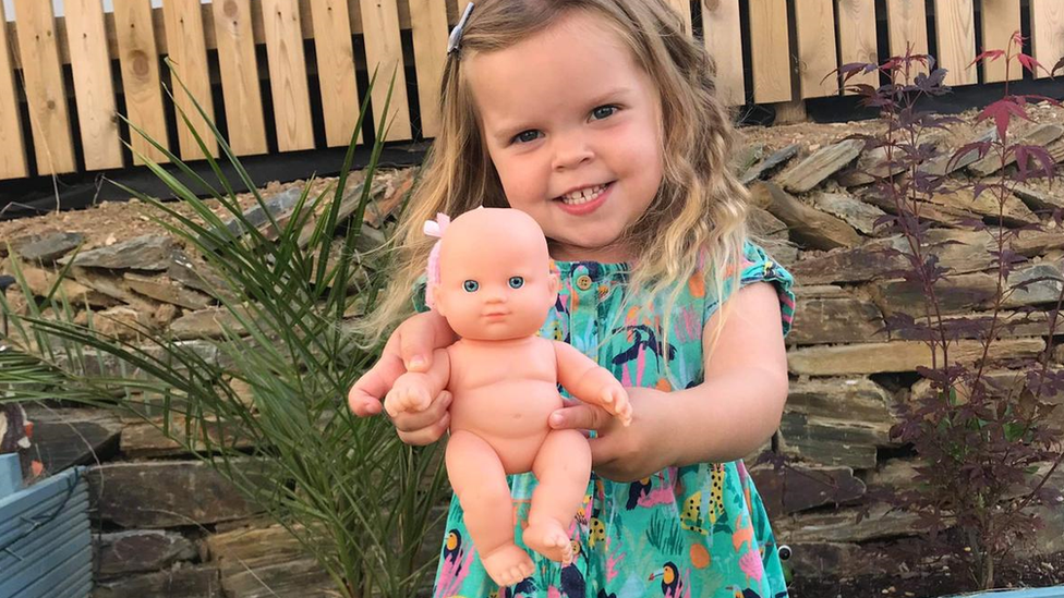 Young girl holding her doll