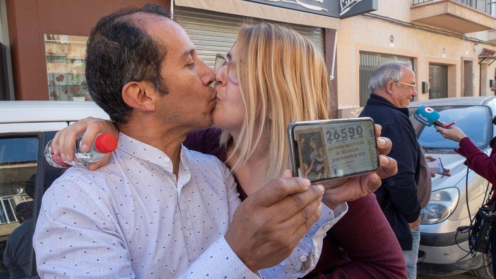 Couple Yesica Garcia (R) and Alexander Zambrano (L) celebrate at the lottery administration Virgen de La Salceda where they bought their winning ticket.