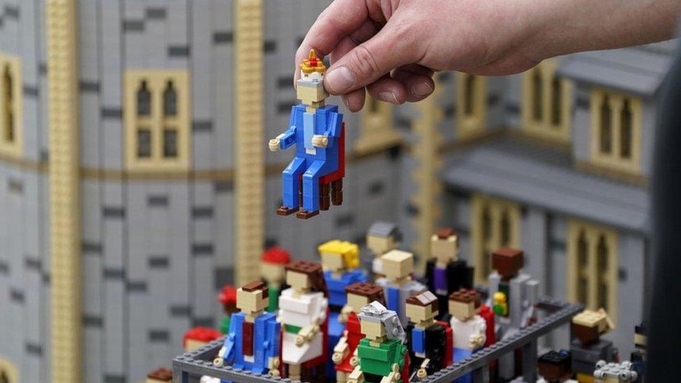 Model maker Francis Carruthers from the Legoland Windsor Resort, places a Lego model of King Charles III into a Windsor Castle concert miniland scene