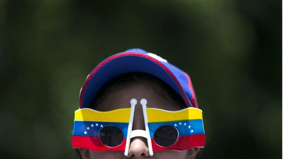 A woman wears Venezuelan flag motif glasses during a protest demanding a recall referendum against Venezuela"s President Nicolas Maduro Caracas, Oct. 22, 2016.