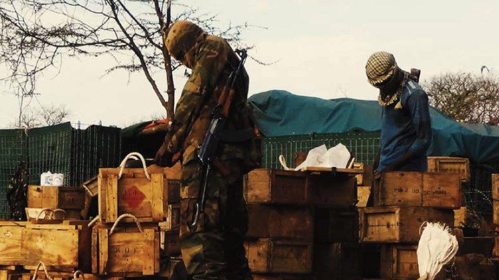 A photo released by al-Shabab showing militants looking through boxes allegedly in el-Ade