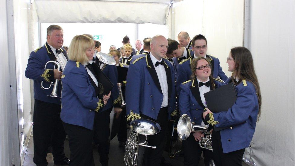 Mae'n ddiwrnod mawr i'r bandiau pres heddiw a dyma fand Saint Athan yn paratoi i fynd ar y llwyfan // RAF St Athan Voluntary Band get ready to take centre stage