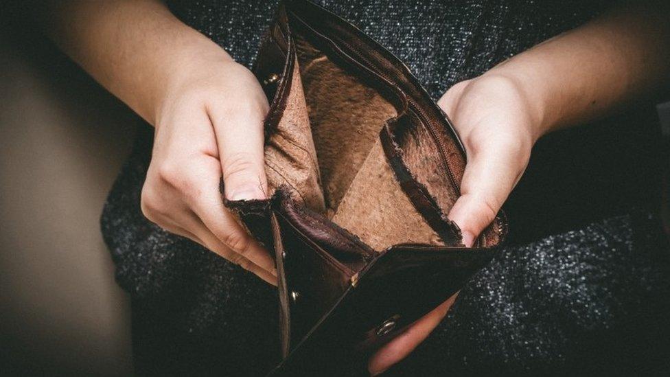 Old empty wallet in the hands of a woman