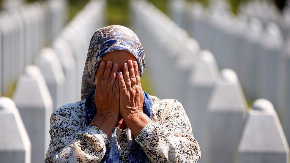 A woman prays at a graveyard, ahead of a mass funeral in Potocari near Srebrenica on Saturday