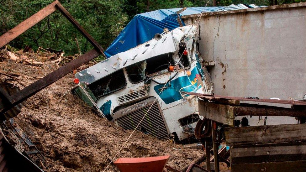 Truck covered by mud beside a building in Queja, Guatemala, on 7 November 2020