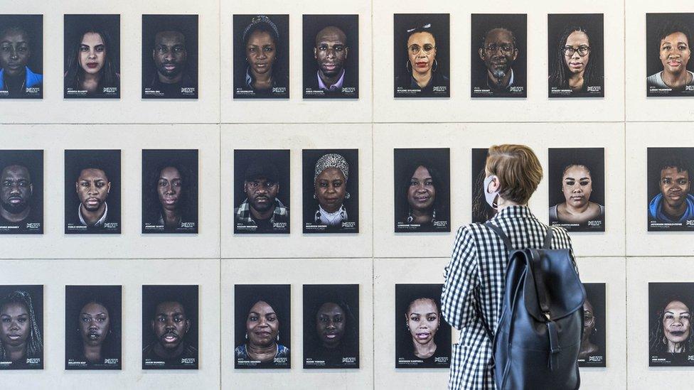 A member of the public looks at an art installation called Portrait of Black Britain, by Cephas Williams