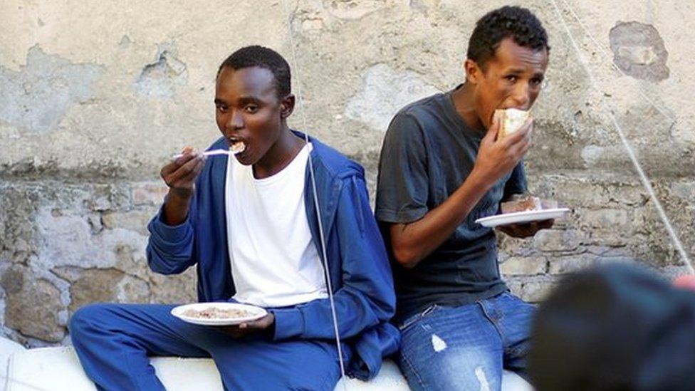 Migrants are fed by an NGO at a makeshift camp in Rome