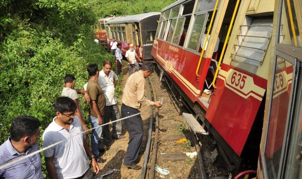 People gather at the site of the derailment of a chartered narrow gauge train