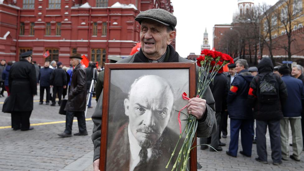 Man holds portrait of Lenin