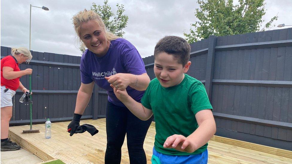 A little boy being led by a helper