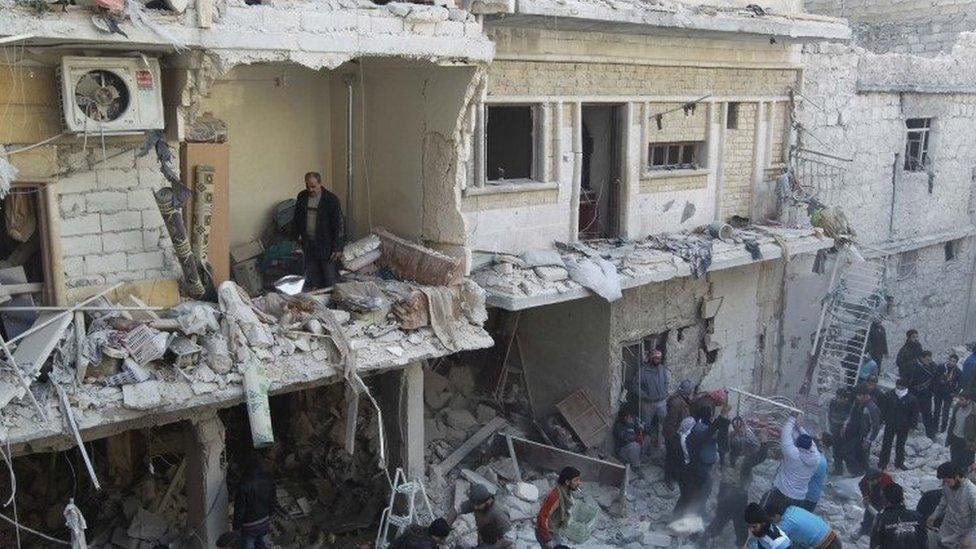 Residents search for survivors after what activists say was an air raid in Aleppo, 28 December 2013