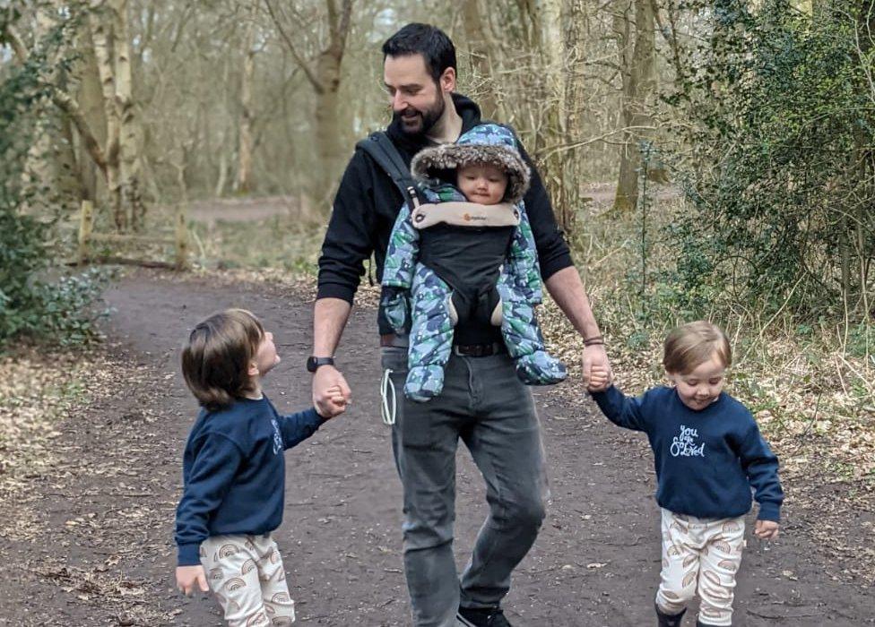 Leigh Harris walking through woodland with his three sons