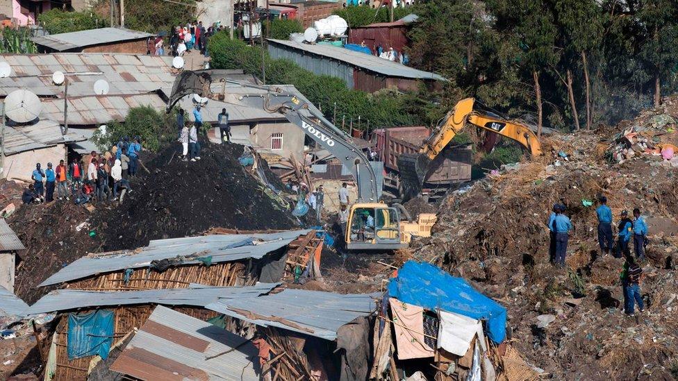 Excavators move earth as rescuers work at the site of a landslide at the main landfill of Addis Ababa on the outskirts of the city on March 12, 2017