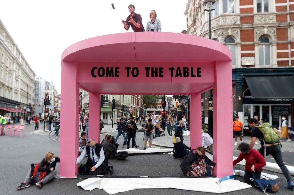 Extinction Rebellion protesters building a pink table