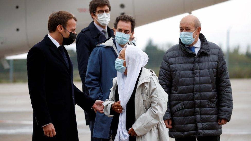 French President Emmanuel Macron welcomes French aid worker Sophie Petronin who was freed from captivity in the hands of Islamist insurgents upon her arrival at the Villacoublay military airport near Paris, France October 9, 2020