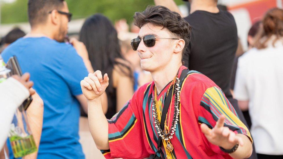 man dancing in a colourful African top