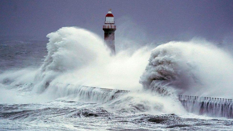 Waves crashing against the sea wall at Roker lighthouse in Sunderland