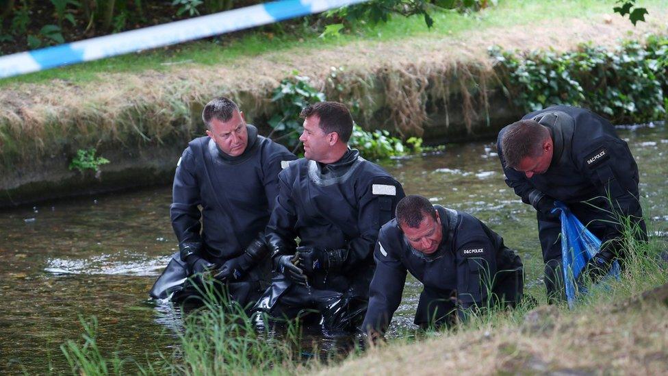 Officers searching a stream in Queen Elizabeth Gardens in July