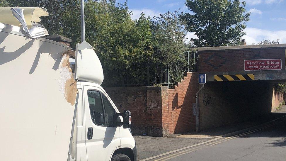 Luton van with damage to the top of its roof