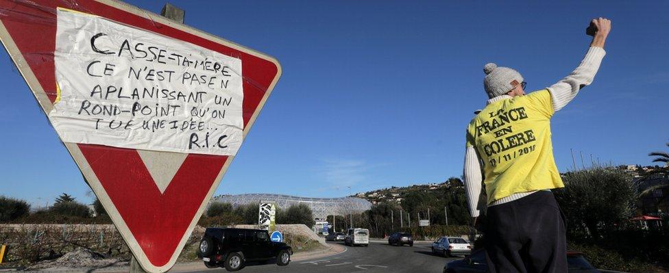 A yellow vest movement member wearing a T-shirt which reads "France is Angry" raises his fist on a roundabout in Nice, France, January 11, 2019