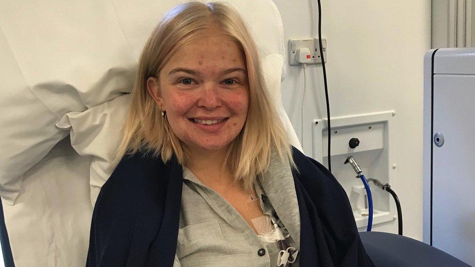 Image of Hattie at dialysis treatment. She is pictured in a chair, smiling at the camera. Her dialysis line can be seen on her chest.