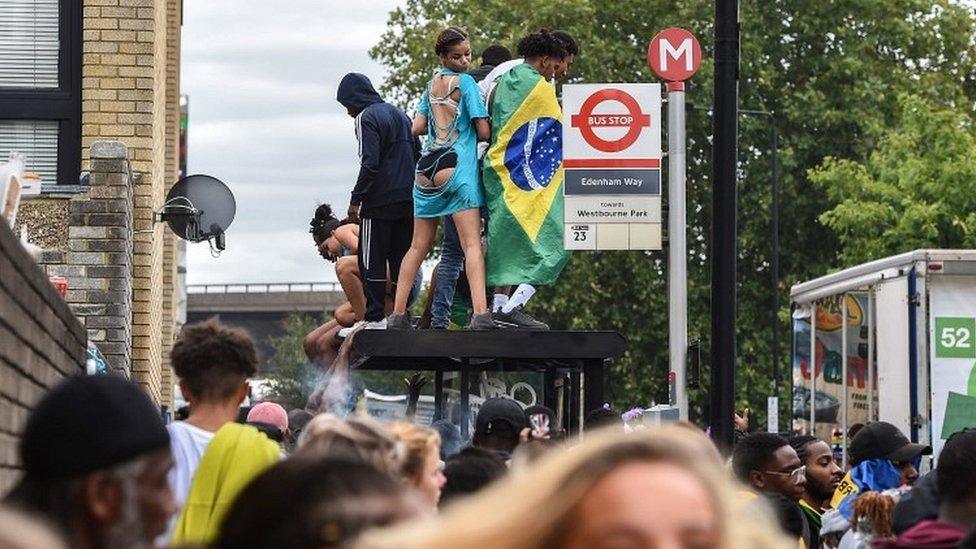 Revellers on top of bus shelter