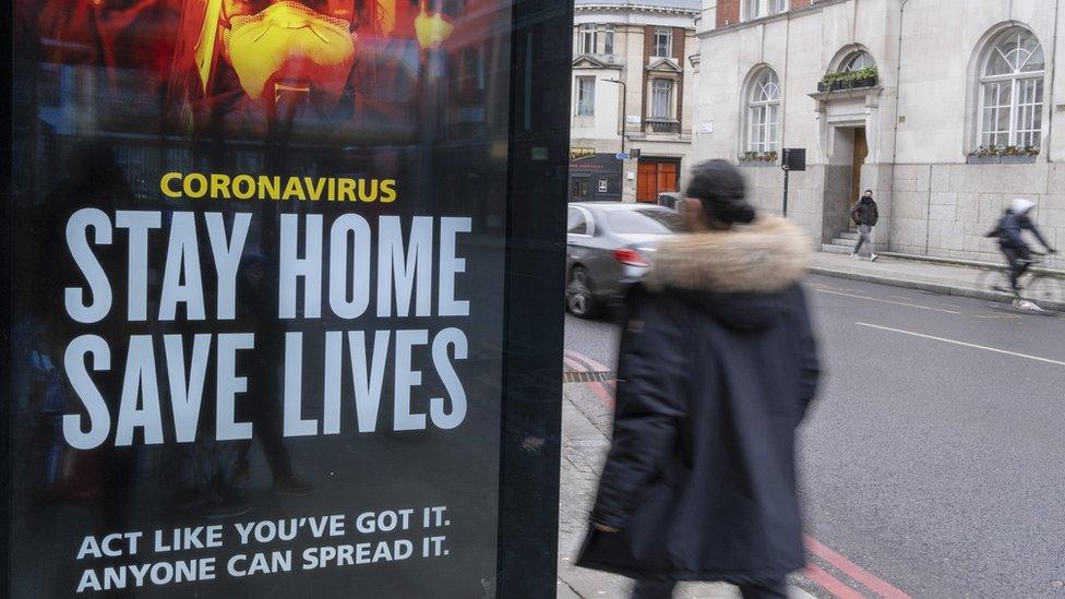 A UK government sign on a bus stop asks people to stay at home