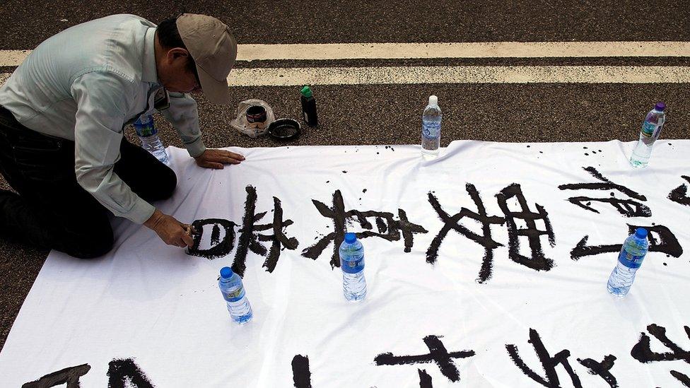 A protester writes slogans in calligraphy outside of Hong Kong Government Complex on September 30, 2014 in Hong Kong