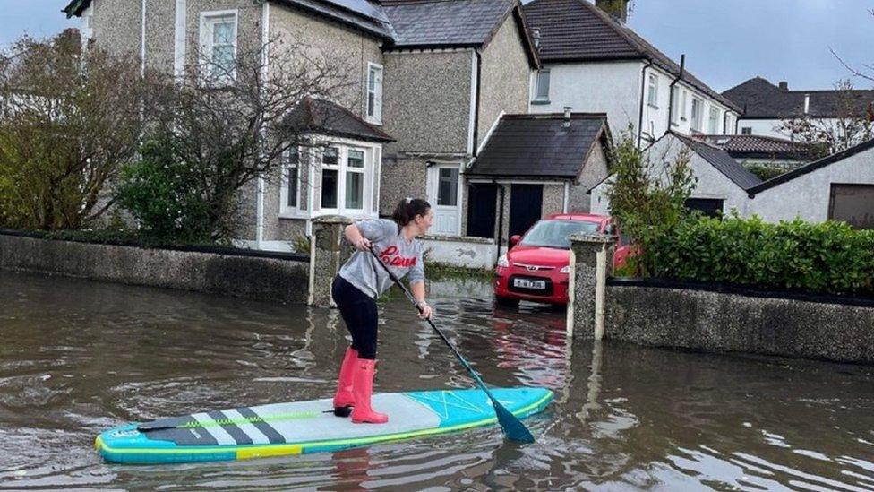 Woman on paddleboard in residential area, Bangor, County Down