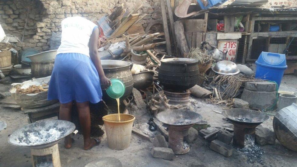 Girl cleaning big metal pots.