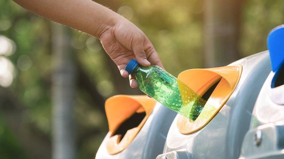 Close up hand throwing empty plastic bottle into the trash Recycling Concept