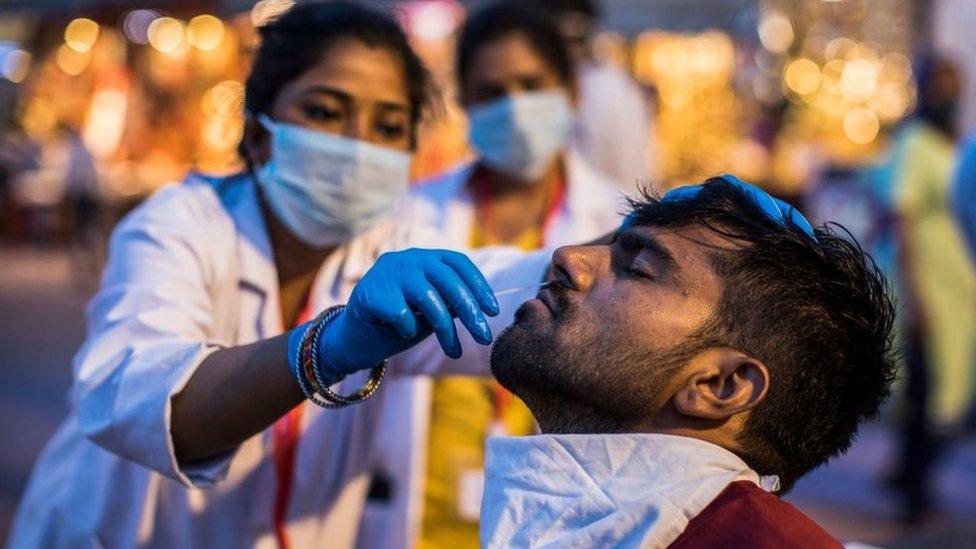 A health worker collects a nasal swab sample from a Hindu devotee to test for the Covid-19 coronavirus during the ongoing religious Kumbh Mela festival in Haridwar on April 12, 2021.