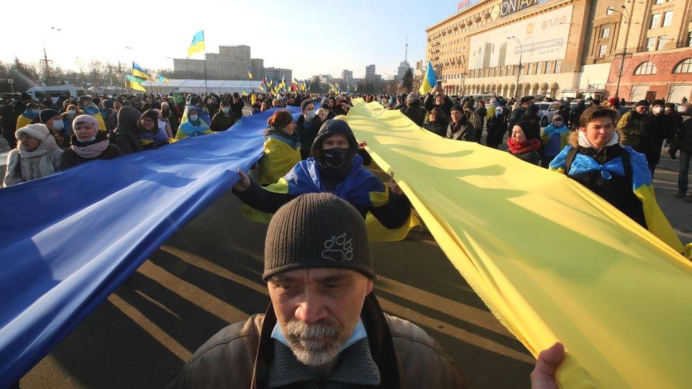 People carry blue and yellow stripes of fabric in the national colours during the Unity March in Kharkiv, northeastern Ukraine, 5 Feb 2022.