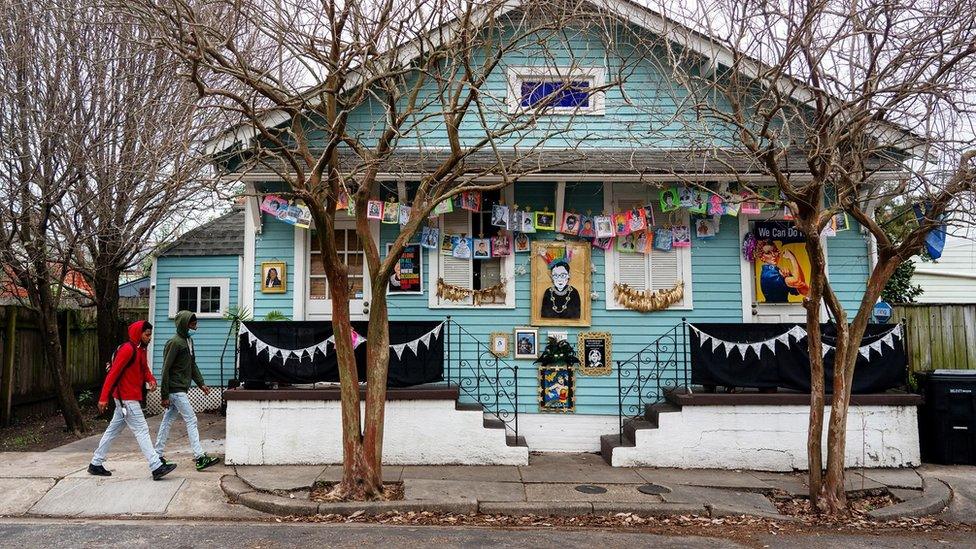 People walk past a house paying homage to influential women