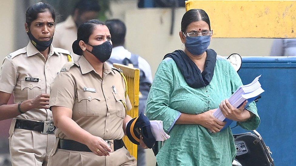 Police escort activist and lawyer Sudha Bharadwaj (R) towards a van as she leaves jail to appear in a special court ahead of her release on bail on the 2018 Bhima Koregaon case in Mumbai on December 8, 2021.