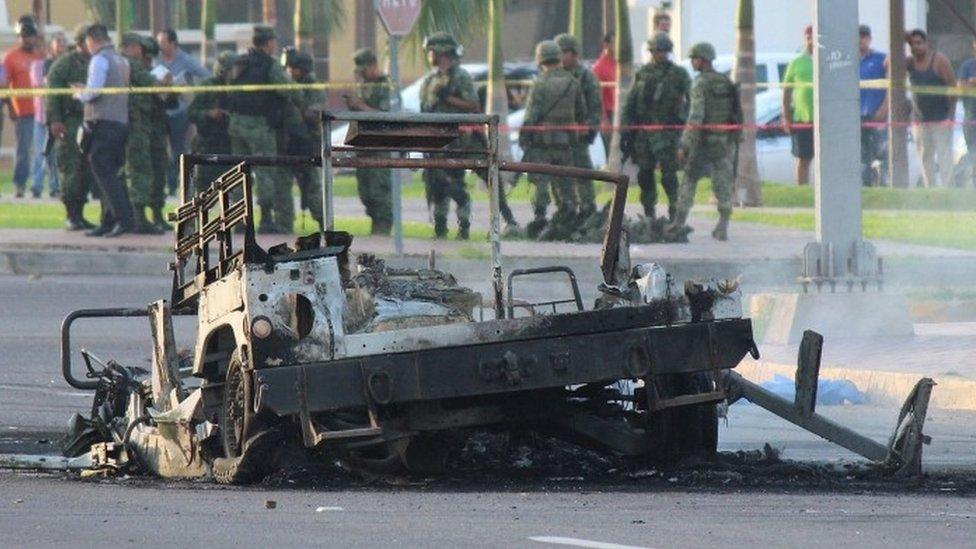 The burnt wreckage of a military vehicle after what local media said was an ambush by gunman on a military convoy to free an injured fellow gunman from an ambulance, in Culiacan, in Sinaloa state, Mexico (30 September 2016)