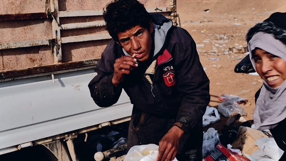 Amer eating from a rubbish dump