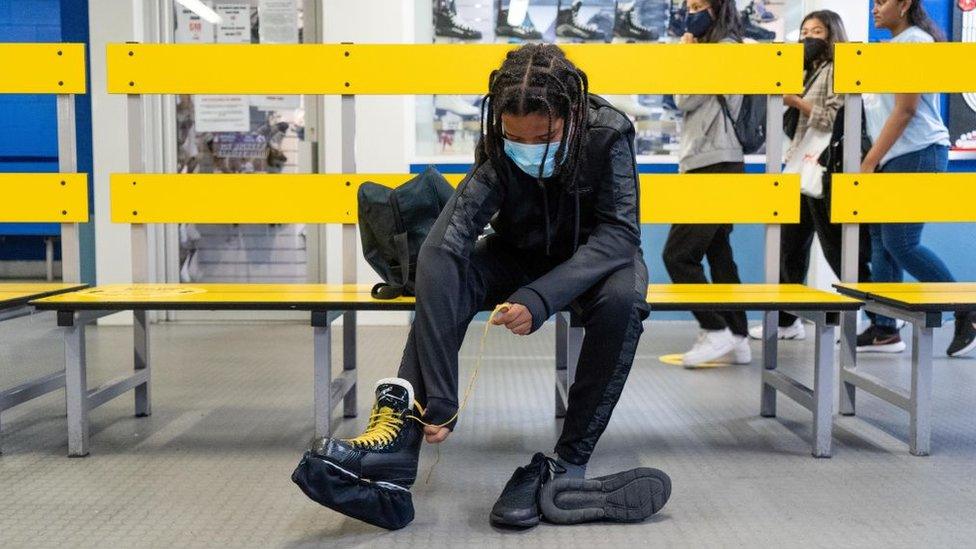 Young man putting ice skates on