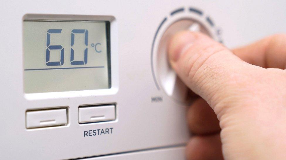 A person adjusting their boiler temperatire