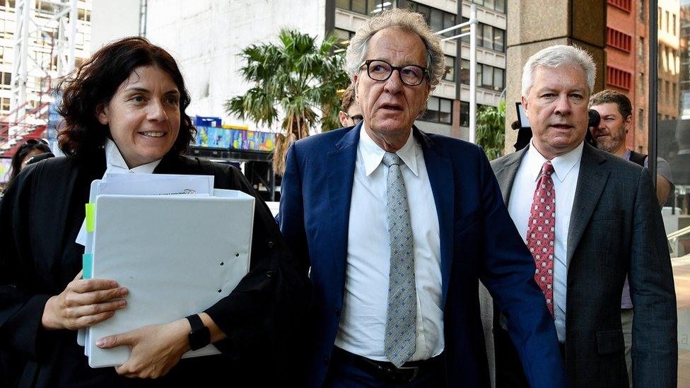 Actor Geoffrey Rush (centre) arrives at the Federal Court in Sydney