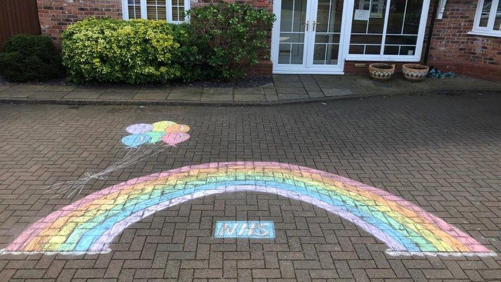 chalk-rainbow-drawing-on-ground-with-rainbow-balloons-and-nhs-logo