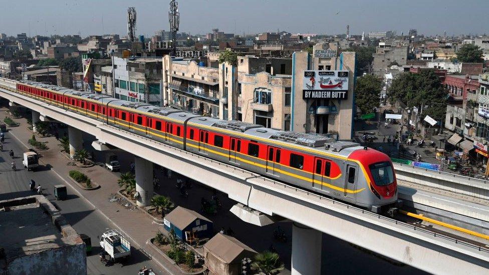 A train runs along the newly built Orange Line Metro in Lahore