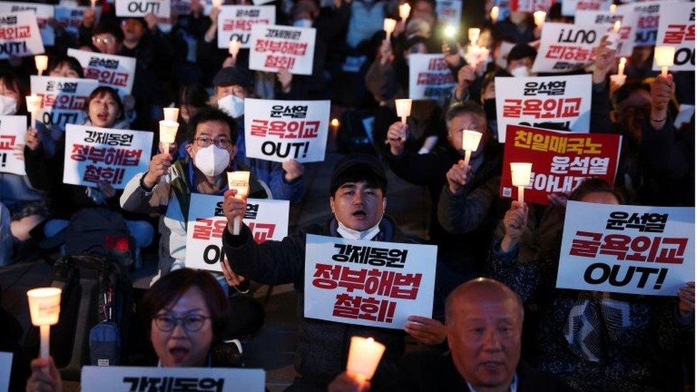 South Korean people chant slogans during a candlelight vigil that denounces a government plan to resolve a dispute over compensating people forced to work under Japan"s 1910-1945 occupation of Korea, in Seoul, South Korea, March 6, 2023.